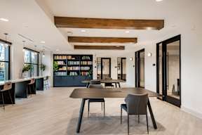 A modern dining room with a long table and chairs.