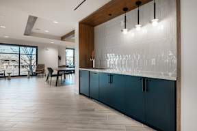 A kitchen with a bar area and a dining table.