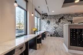 A kitchen with a black and white marble backsplash and wooden floors.