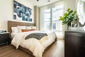 A bedroom with a large bed and a painting on the wall.