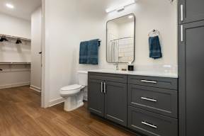 A bathroom with a toilet, a mirror, and a towel.