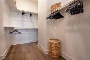 A room with a white wall and a wooden floor with a basket on it.