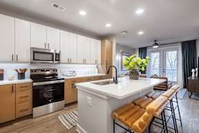A modern kitchen with wooden cabinets and a white island.
