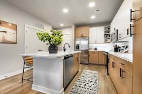 A modern kitchen with wooden cabinets and a white island.