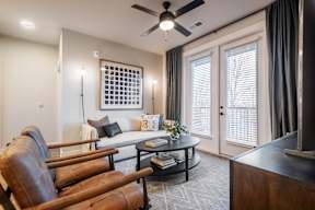 A living room with a brown leather chair and a white sofa.