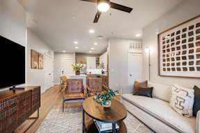 A living room with a brown leather chair and a white couch.