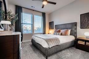A bedroom with a large bed and a ceiling fan.