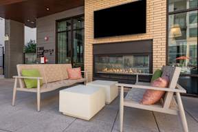 A modern outdoor seating area with a fireplace.