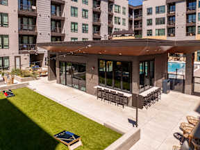 A modern building with a pool and a patio area.