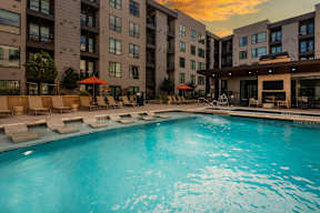 A swimming pool in front of apartment buildings.