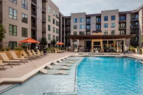 A large swimming pool in front of apartment buildings.