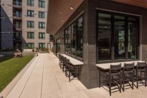 A long row of chairs are lined up on a patio.