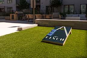 A book titled "The Finch" is placed on a grassy area.