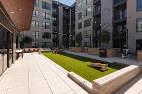 A modern courtyard with a grassy area and a bench.
