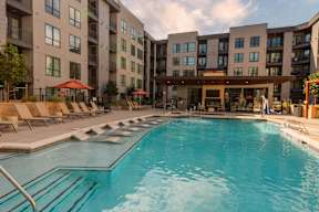 A large swimming pool in front of apartment buildings.