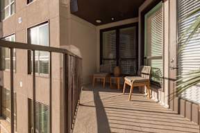 A balcony with a table and chairs is shown.