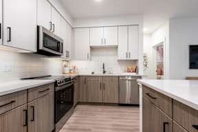 A modern kitchen with wooden cabinets and stainless steel appliances.
