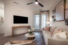 A living room with a couch, a coffee table, and a television.