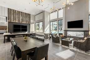A modern living room with a wooden dining table and black chairs.