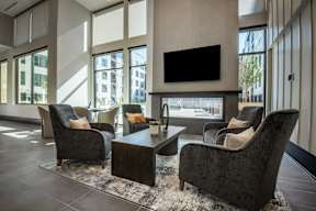 A living room with a black sofa, two armchairs and a coffee table.