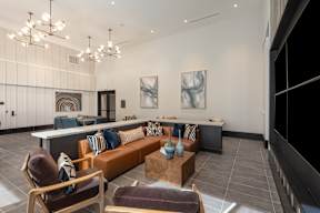 A modern living room with a brown leather chair and a brown leather couch.