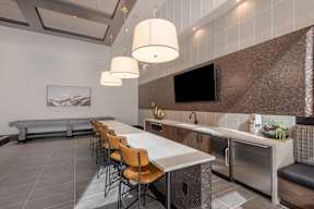 A modern kitchen with a long table and chairs.