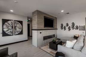 A living room with a grey couch, a fireplace, and a television.