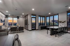 A modern living room with a view of the cityscape at sunset.