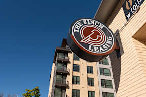 The Finch Leasing sign is hanging on the side of a building.