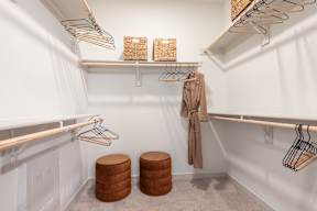 A white closet with a coat hanging on a hanger.