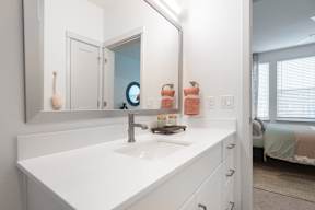 A white bathroom with a sink and mirror.