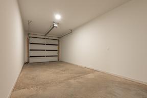 A garage with a closed door and a light on the ceiling.