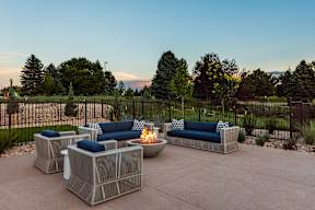 A patio with a fire pit and two couches.