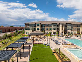 A large building with a pool and a grassy area in front.