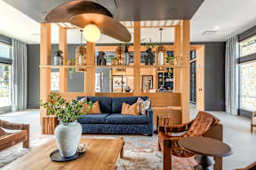 A living room with a blue sofa and a wooden coffee table.