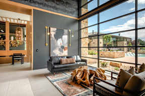A modern living room with a large window and a view of a backyard.