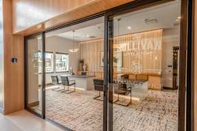 A modern office space with a glass door entrance and a leasing office inside.