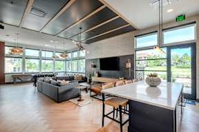 A modern living room with a grey sofa and a white countertop.