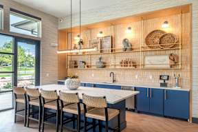 A kitchen with a table and chairs and a counter with a sink.