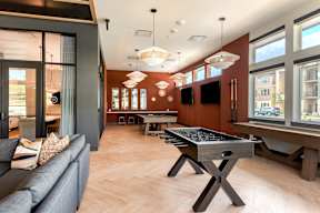 A modern living room with a pool table and a couch.