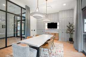 A modern dining room with a large table and chairs.