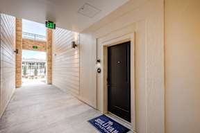 A hallway with a blue doormat that says "SULLIVAN" on it.
