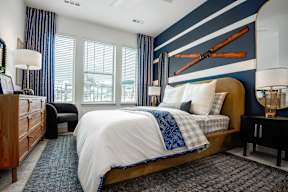 A bedroom with a bed, nightstands, and a window with blinds.