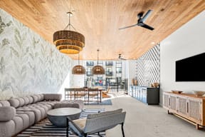A modern living room with a grey sofa and a wooden ceiling.