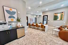 A reception area with a desk, chairs, and artwork on the walls.
