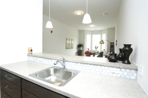 Model kitchen with wooden cabinets and light grey counter top