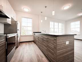 A modern kitchen with a wooden island and stainless steel appliances.