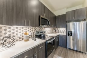 Cozy Kitchen Space with wooden cabinets at Residences at 3000 Bardin Road, Grand Prairie