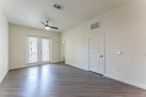 Living room with a ceiling fan and french doors with natural lights at Residences at 3000 Bardin Road, Grand Prairie, TX, 75052