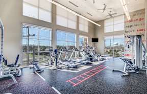 a gym with cardio machines and windows with a view of the city at Republic at Alamo Heights, San Antonio, TX